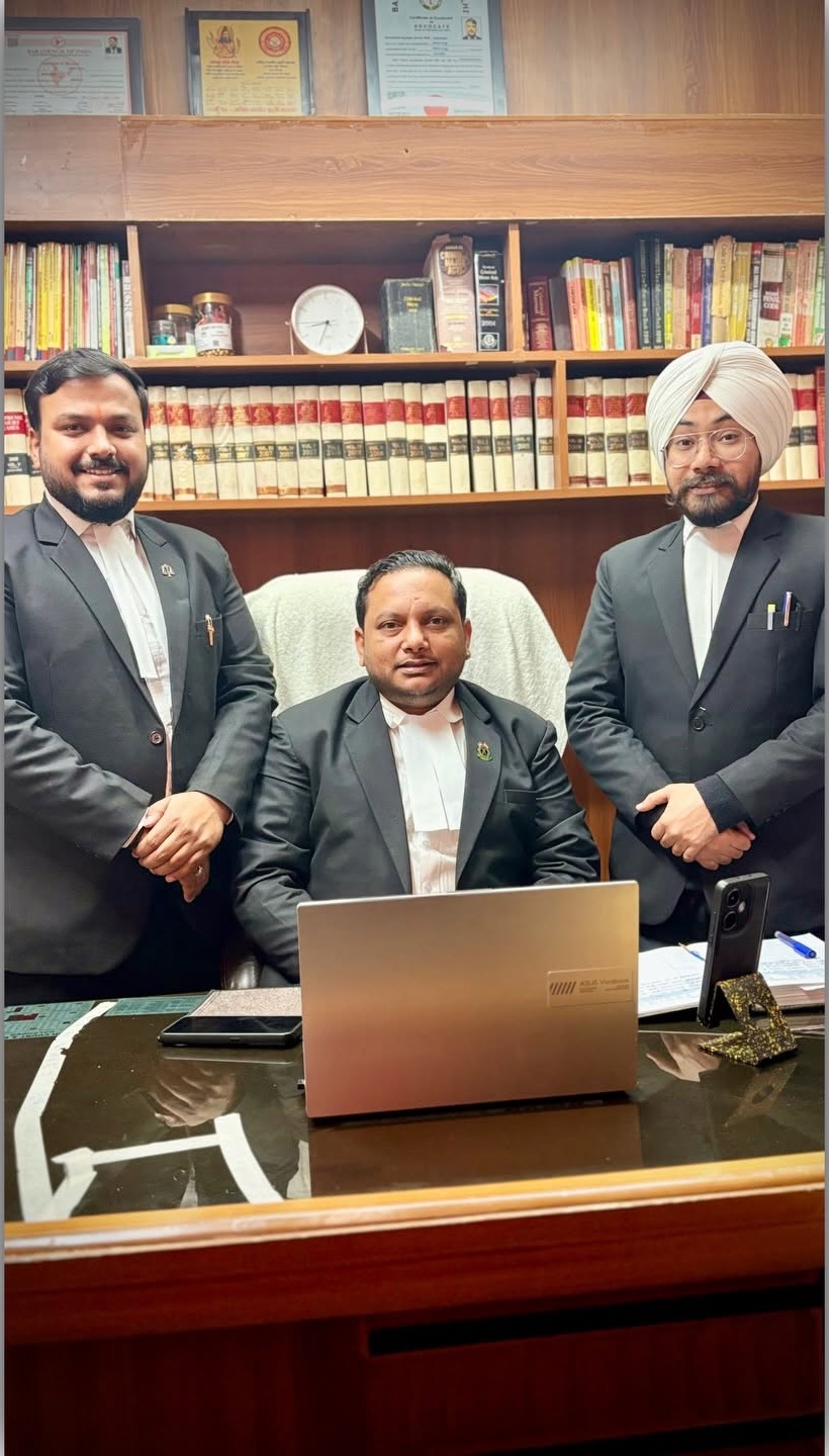 Advocates in court robes in chambers, before shelves of law reports